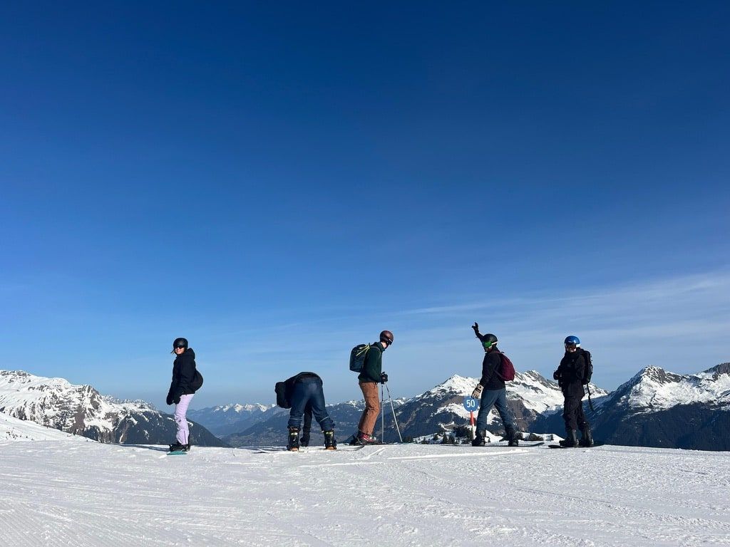 Friends standing on a snowy mountain ridge